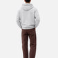 Person wearing a gray hoodie and brown pants on a white background