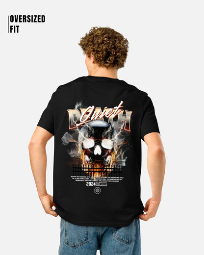 Person wearing a black t-shirt with a graphic design on the back, standing against a white background.